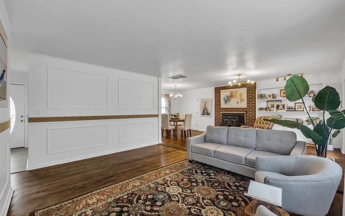 Completed living area with refined wall trim, wood flooring, and coordinated furnishings