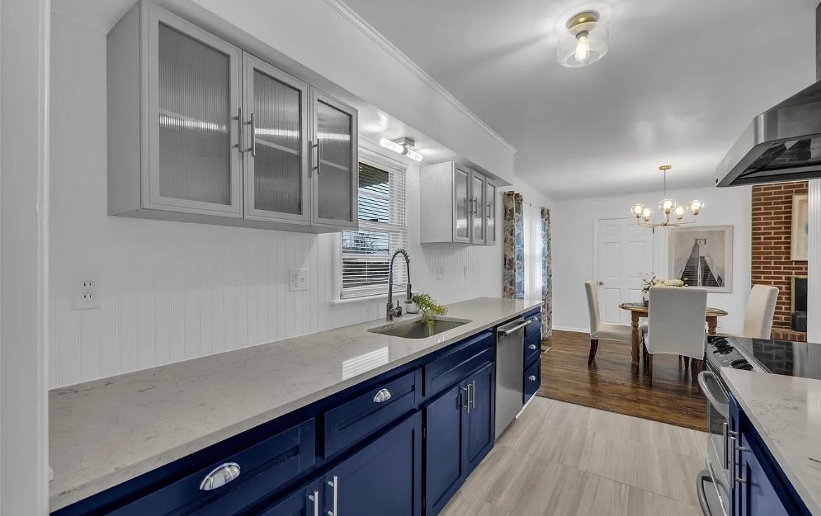 Updated kitchen with navy lower cabinetry and light countertops