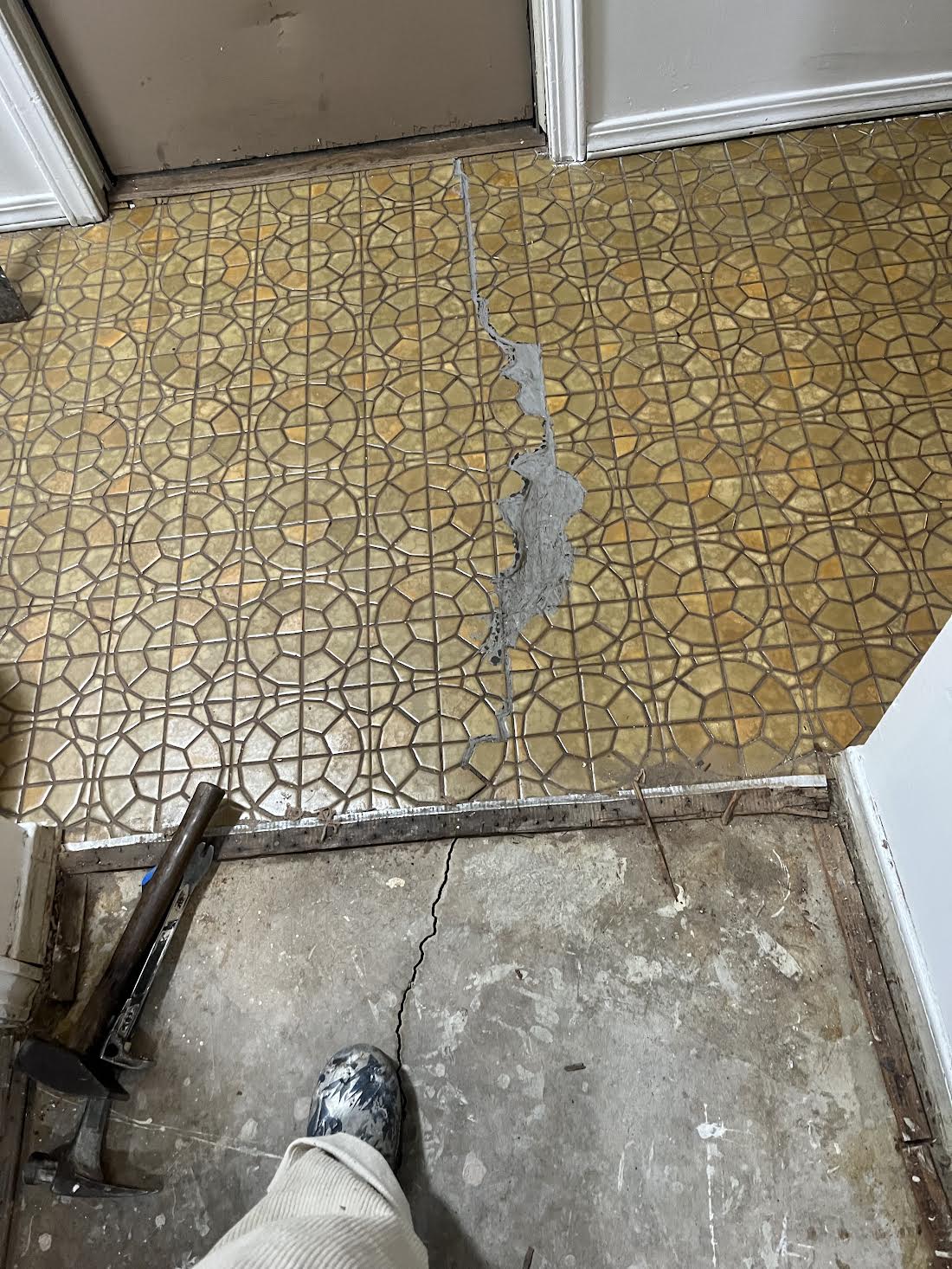 Damaged patterned flooring before removal and replacement